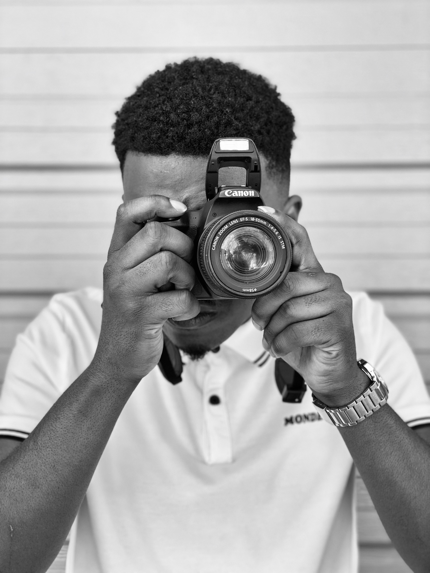 Shae holding a Canon DSLR camera, photographed in black and white